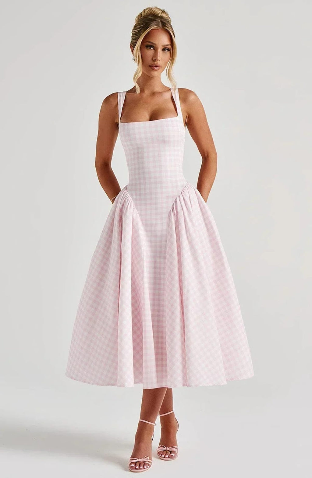 Woman wearing a gingham midi dress with a structured bodice.