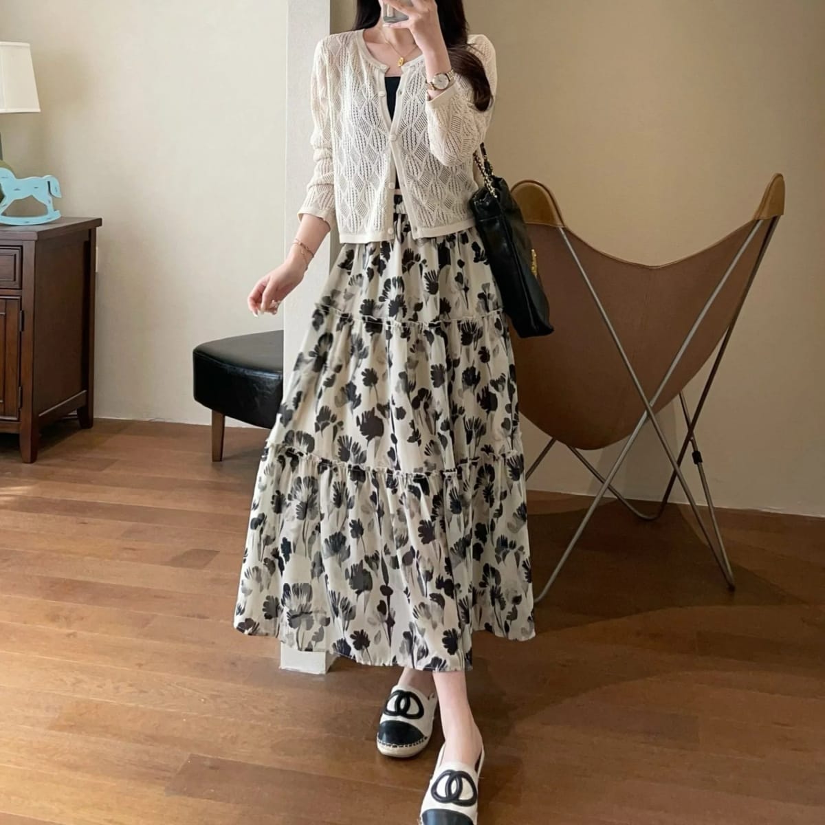 Woman in tiered maxi dress with floral print and cardigan.