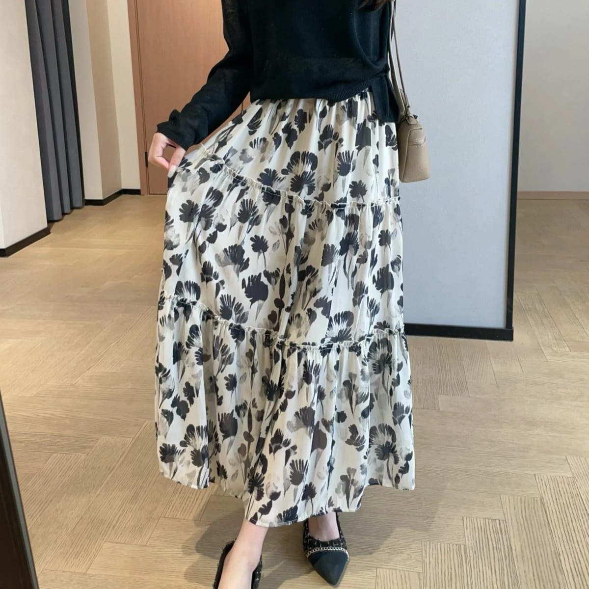 Woman in tiered maxi dress with floral print and cardigan.