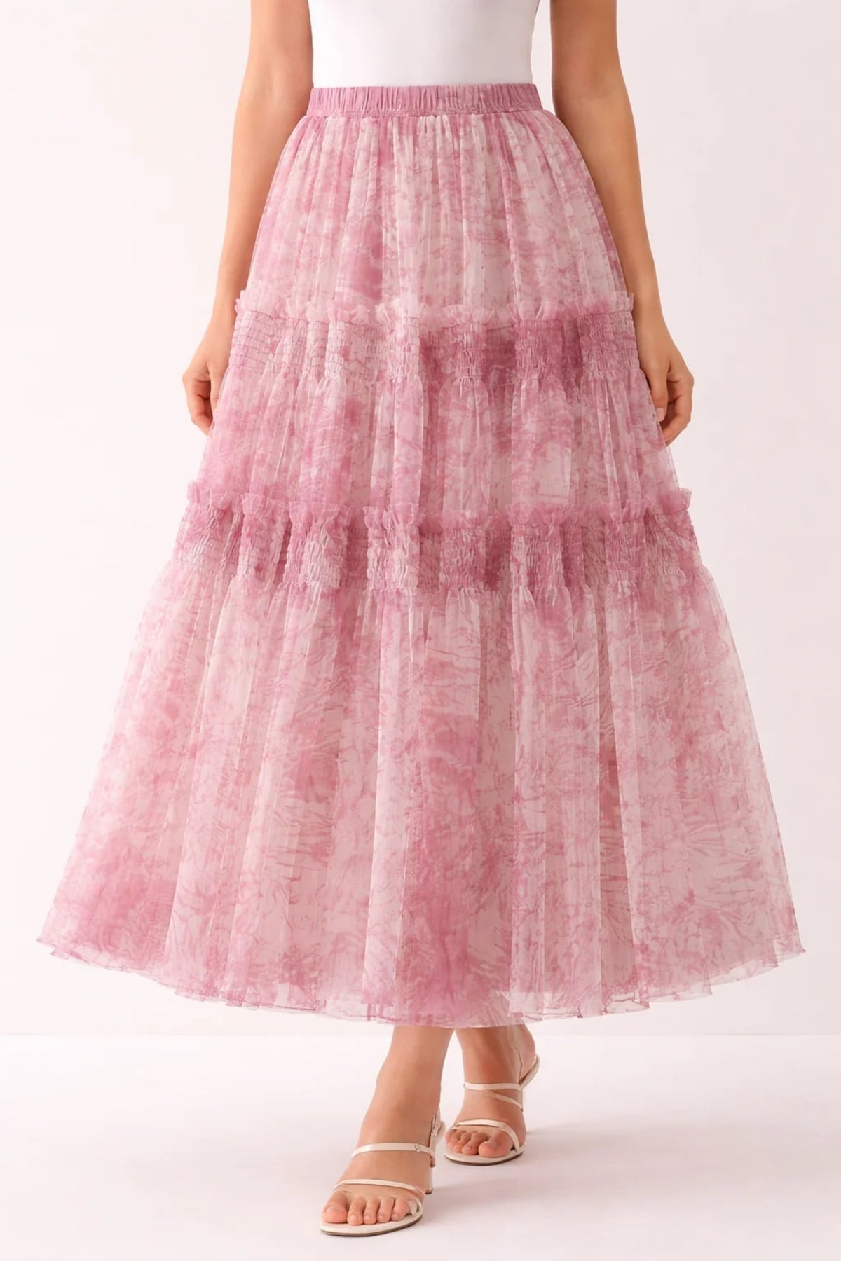 Woman in high-waisted tiered maxi skirt with abstract print.