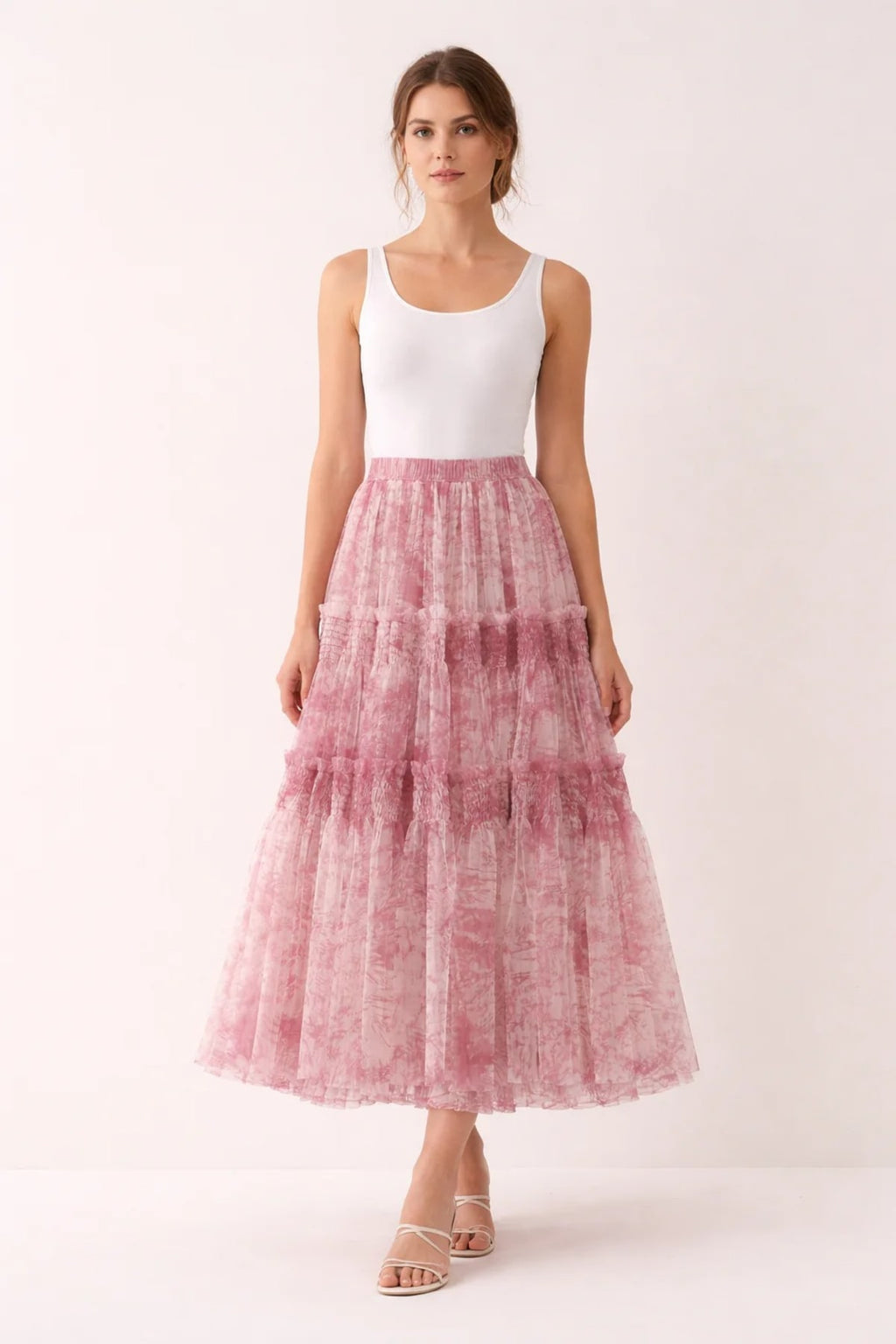 Woman in high-waisted tiered maxi skirt with abstract print.