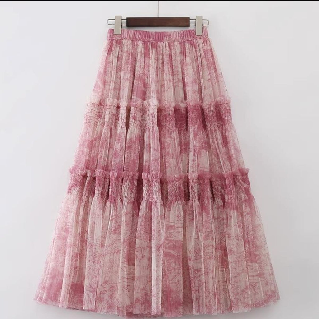 Woman in high-waisted tiered maxi skirt with abstract print.
