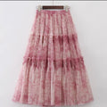 Woman in high-waisted tiered maxi skirt with abstract print.