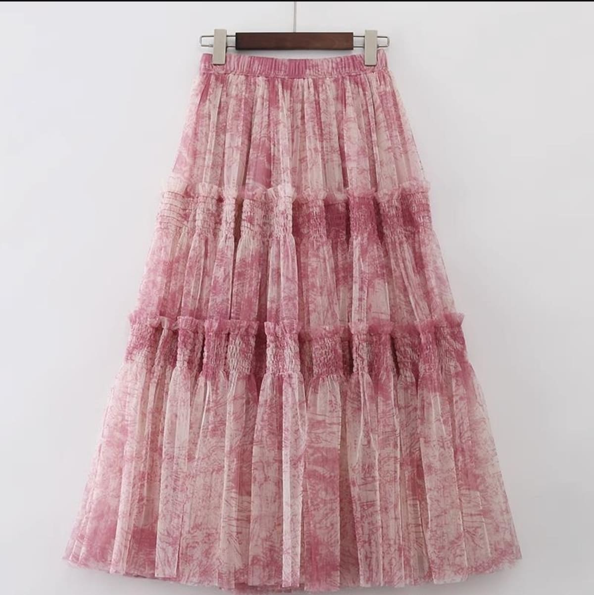 Woman in high-waisted tiered maxi skirt with abstract print.