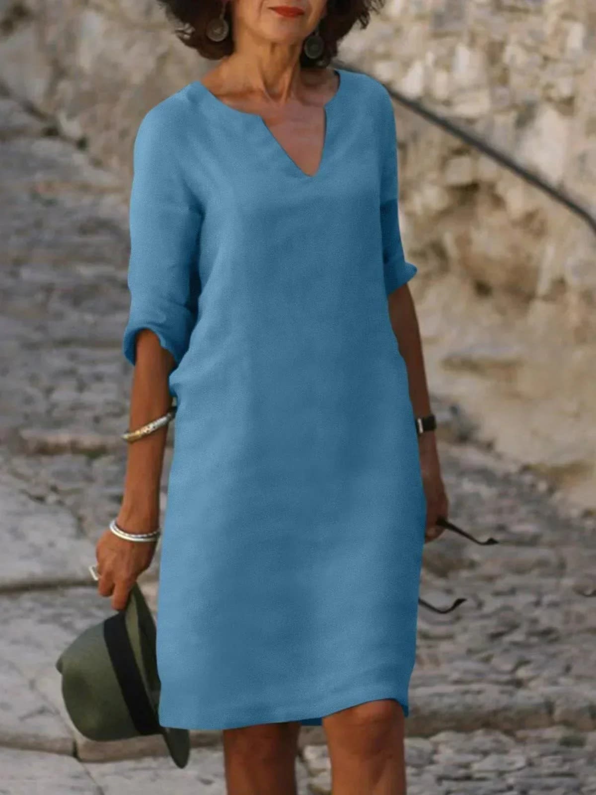 A dress with V-neck and pleated details, layered design.