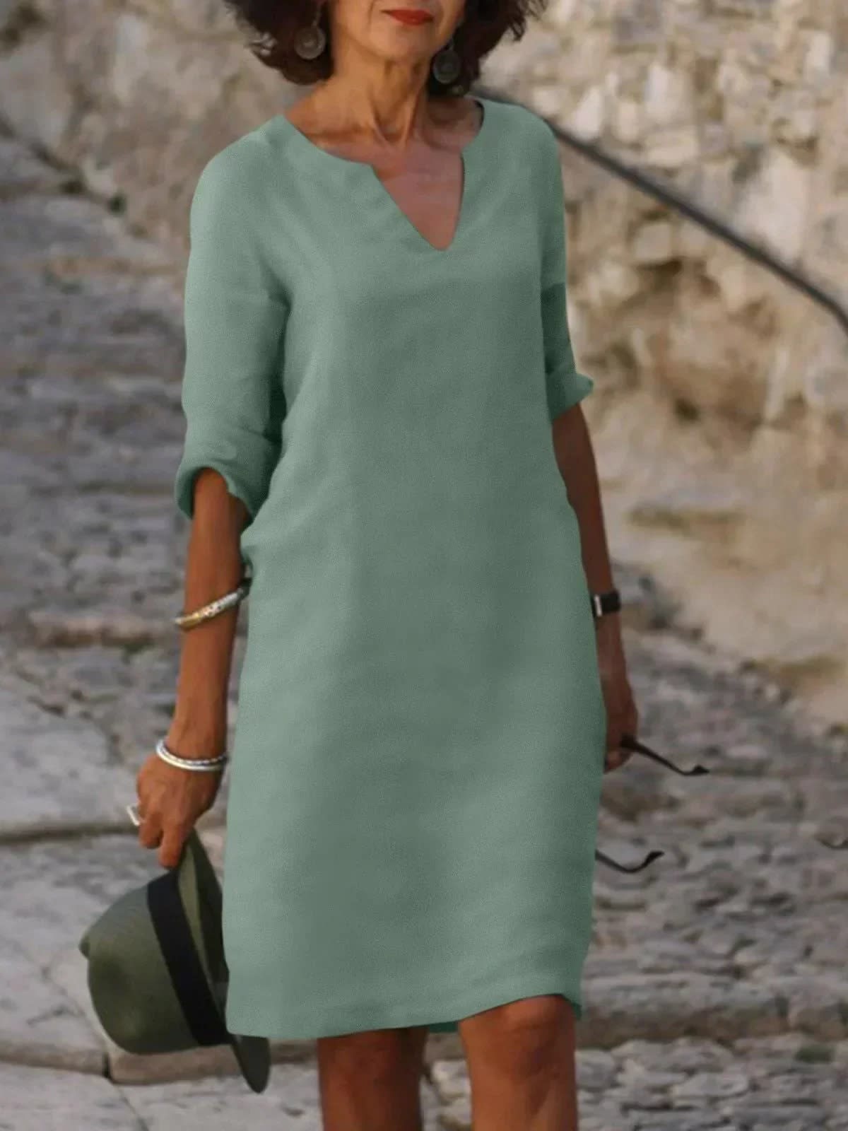 A dress with V-neck and pleated details, layered design.