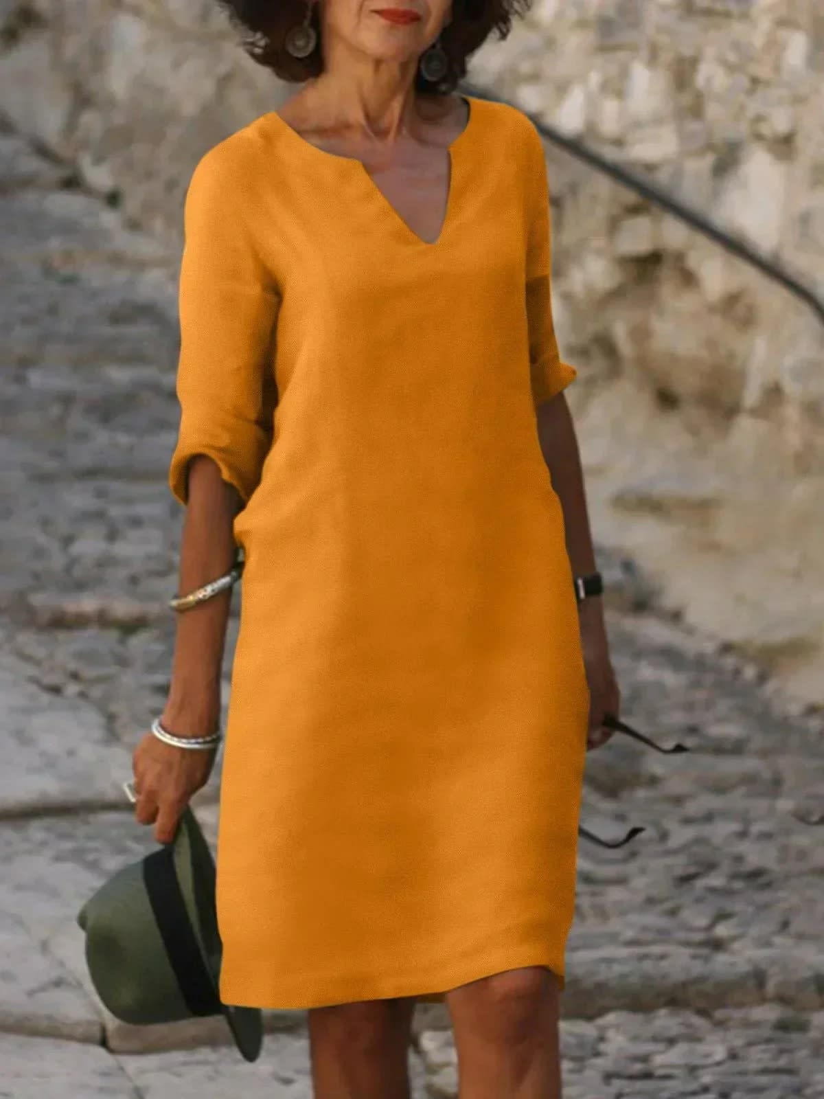 A dress with V-neck and pleated details, layered design.