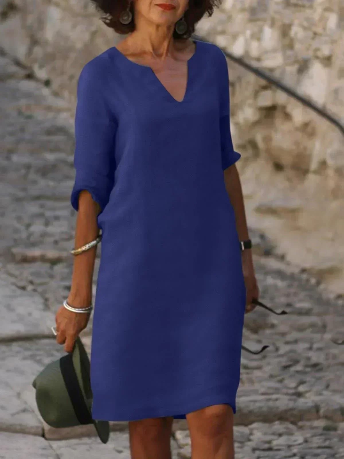 A dress with V-neck and pleated details, layered design.