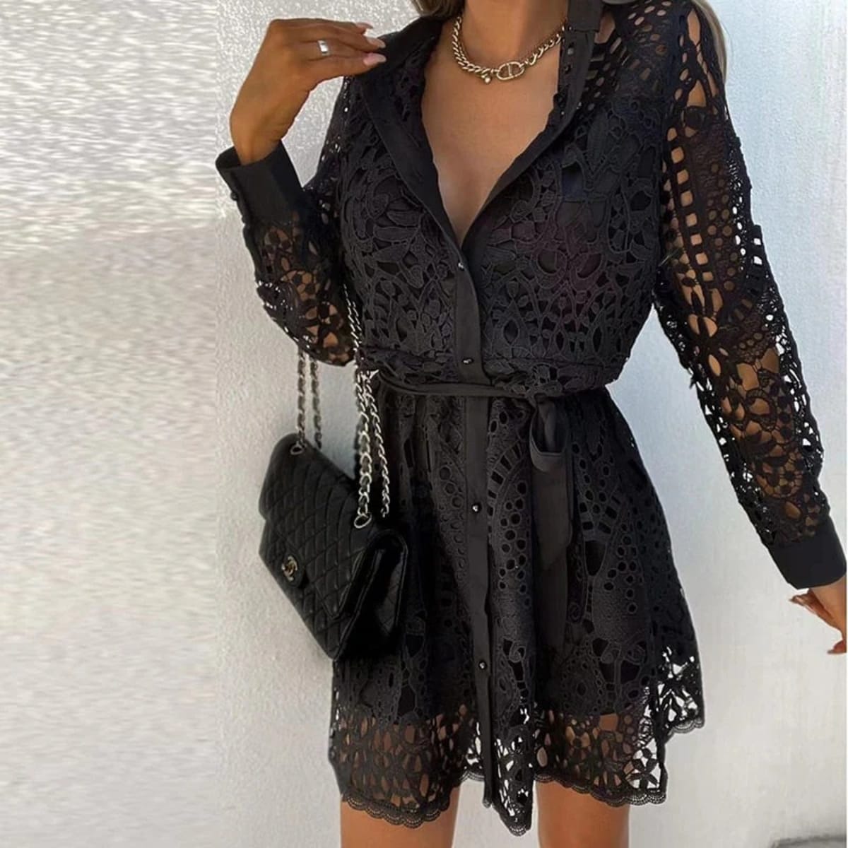 Lace mini dress with long sleeves and belted waist.