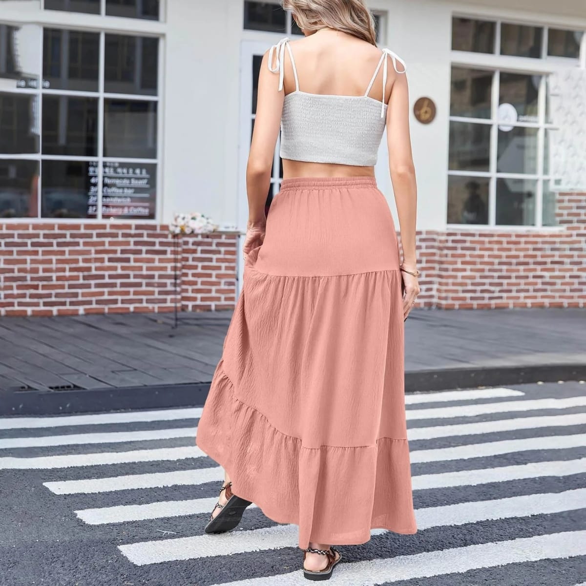Woman wearing a tiered maxi skirt with a side slit and crop top.