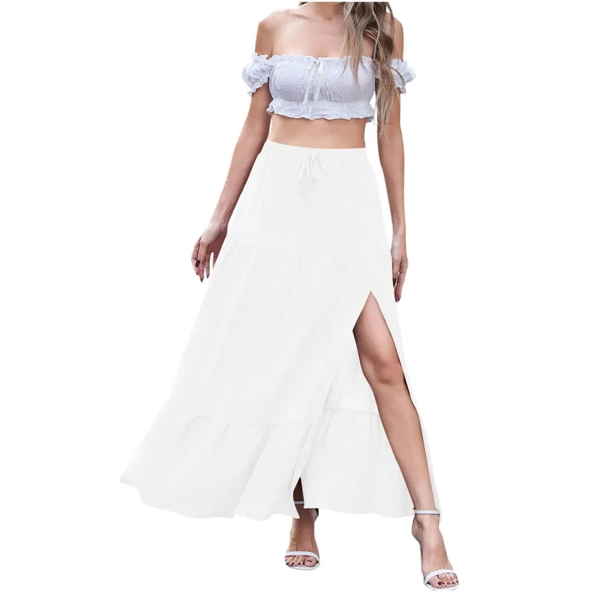 Woman wearing a tiered maxi skirt with a side slit and crop top.
