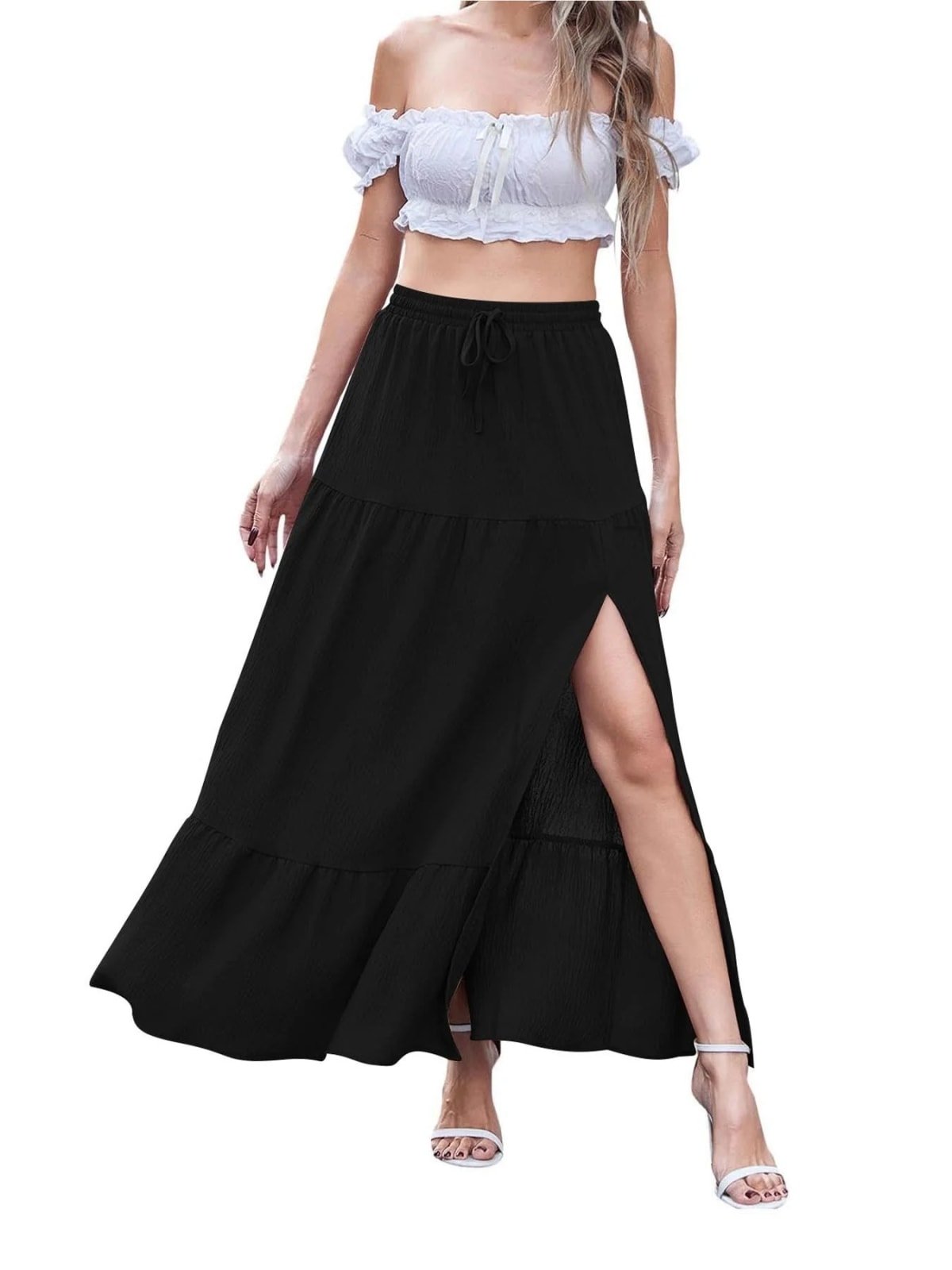 Woman wearing a tiered maxi skirt with a side slit and crop top.