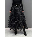 Woman wearing a voluminous appliqued mesh maxi skirt.
