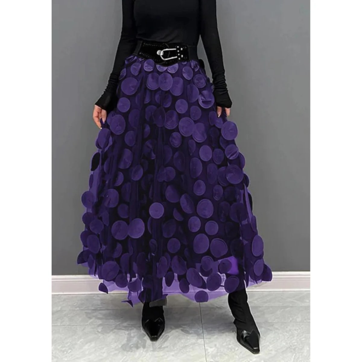 Woman wearing a voluminous appliqued mesh maxi skirt.