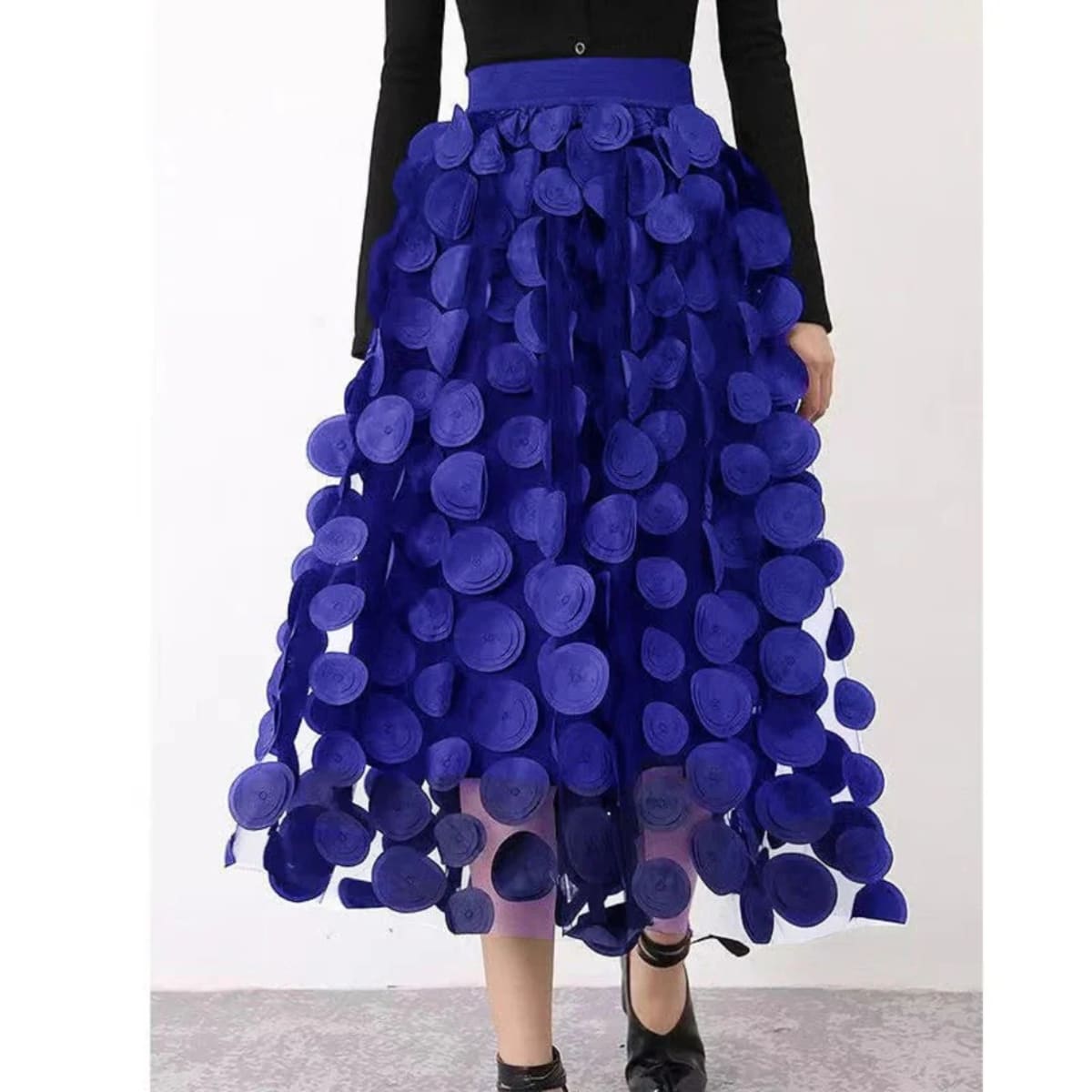 Woman wearing a voluminous appliqued mesh maxi skirt.