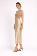 Woman modeling a two-piece crop top and maxi skirt set with lace hem.