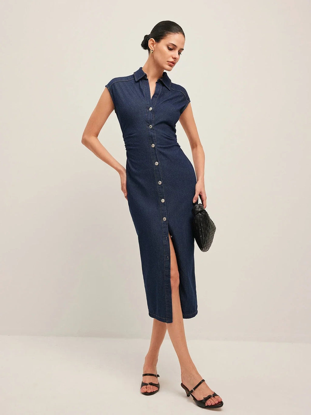 Woman wearing denim midi dress with cap sleeves and button-front.