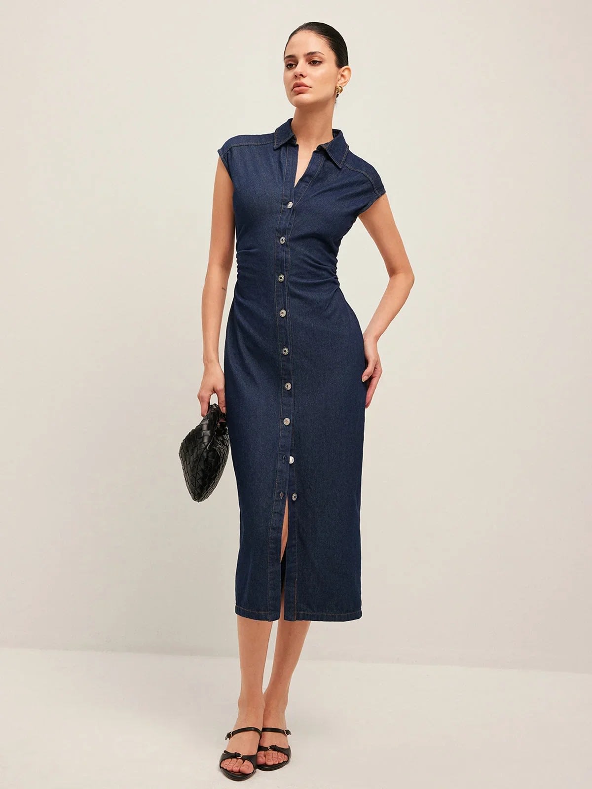 Woman wearing denim midi dress with cap sleeves and button-front.