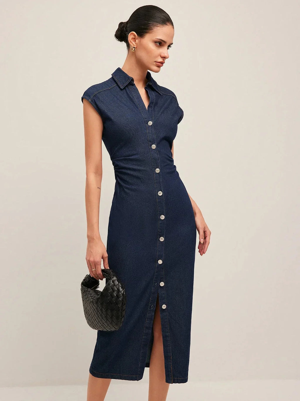 Woman wearing denim midi dress with cap sleeves and button-front.