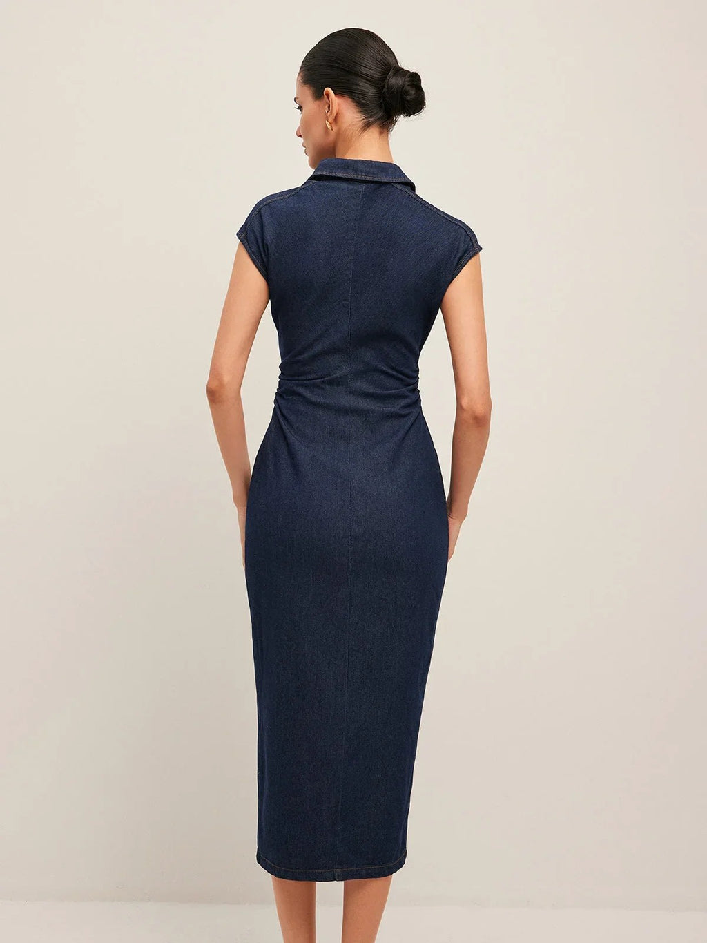 Woman wearing denim midi dress with cap sleeves and button-front.