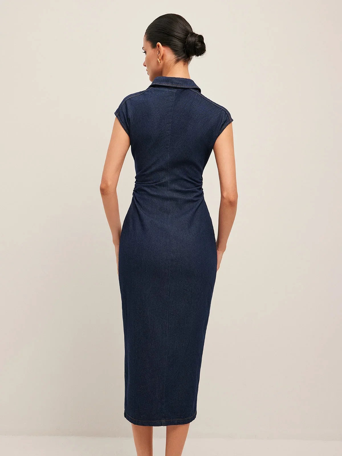 Woman wearing denim midi dress with cap sleeves and button-front.
