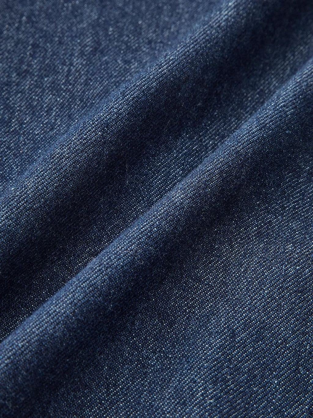 Woman wearing denim midi dress with cap sleeves and button-front.