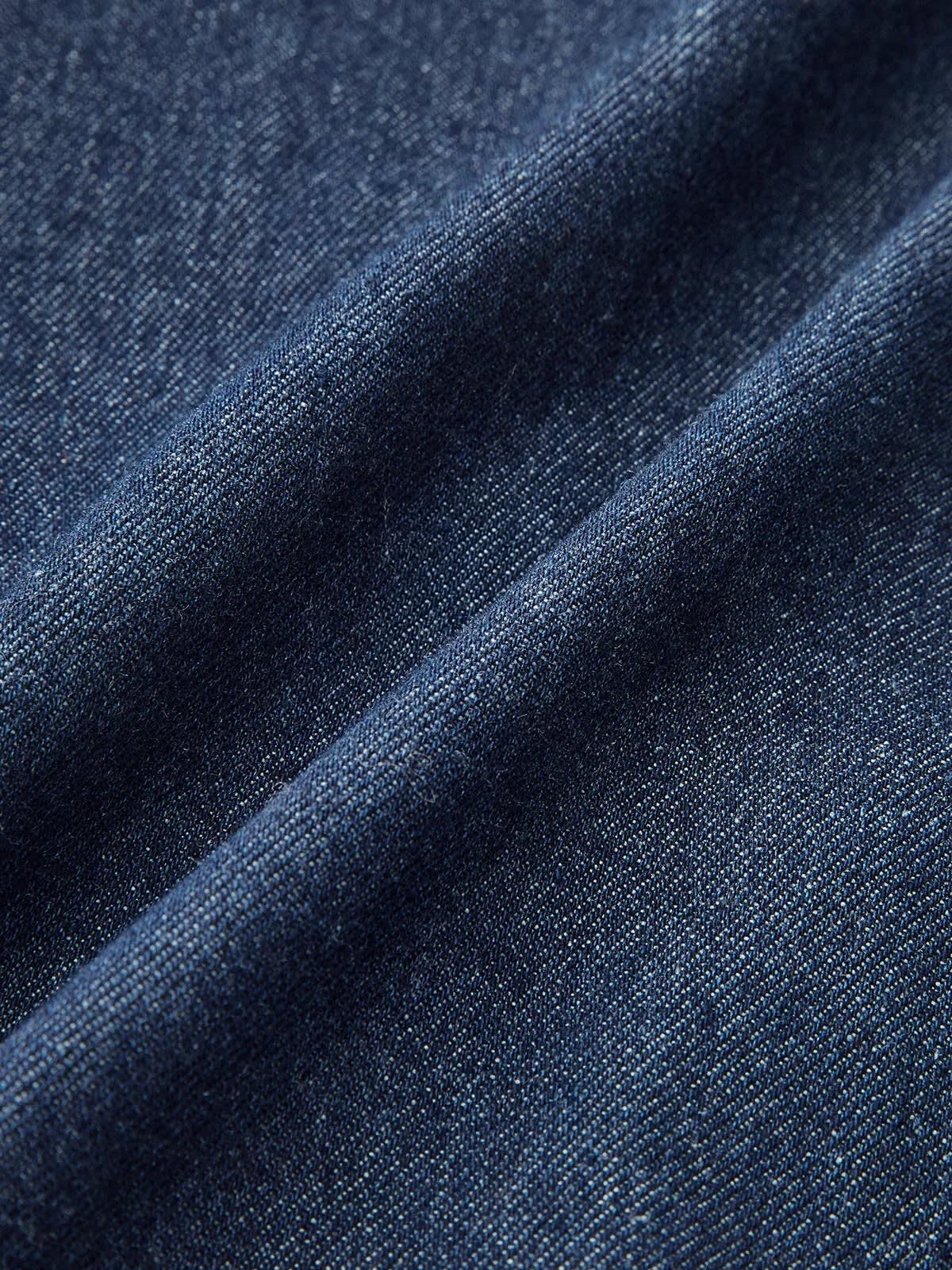 Woman wearing denim midi dress with cap sleeves and button-front.