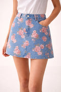 Person wearing floral denim mini skirt with pink roses.