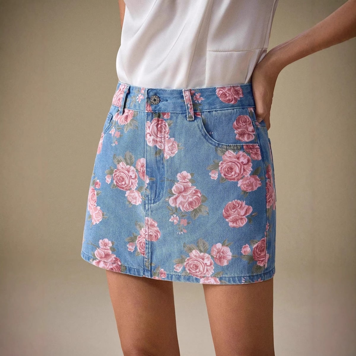 Person wearing floral denim mini skirt with pink roses.