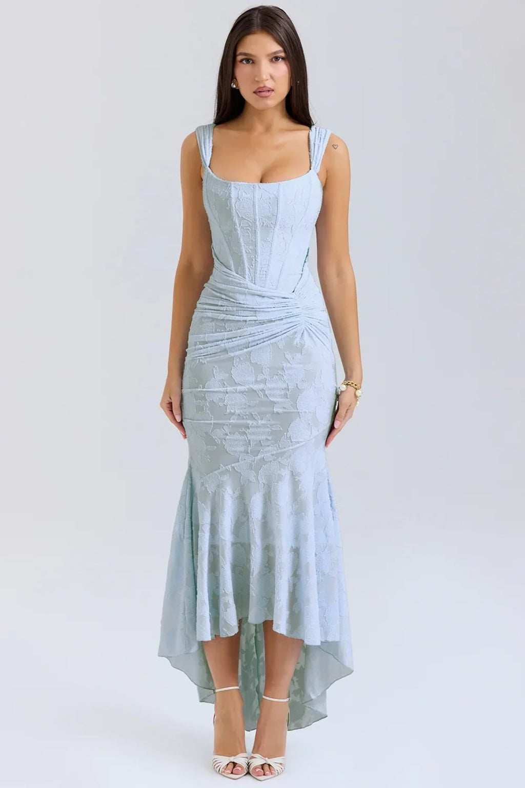Woman in light blue dress with corset bodice, high-low hem.