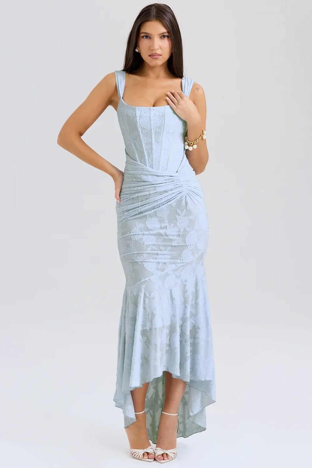 Woman in light blue dress with corset bodice, high-low hem.
