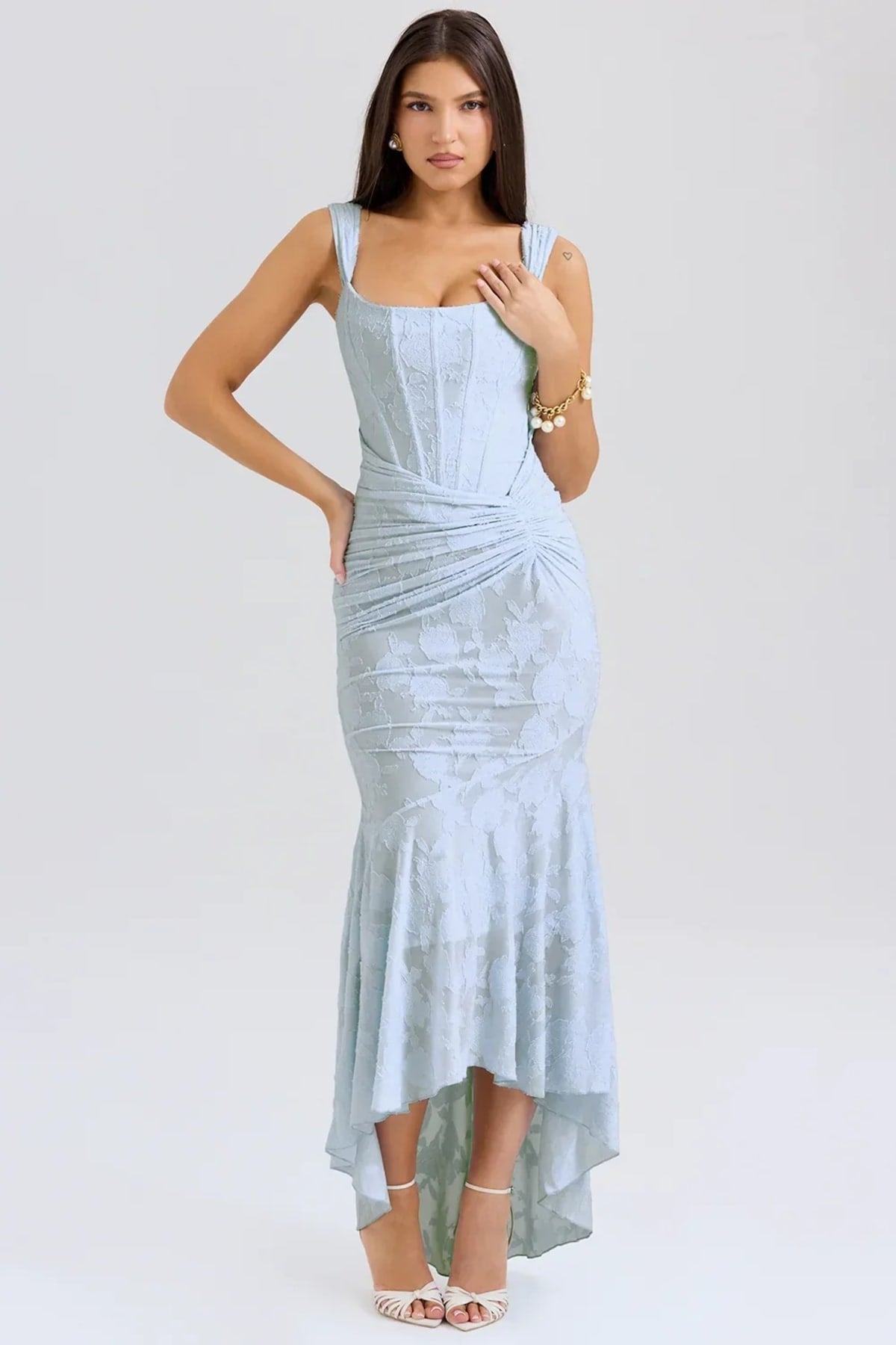 Woman in light blue dress with corset bodice, high-low hem.