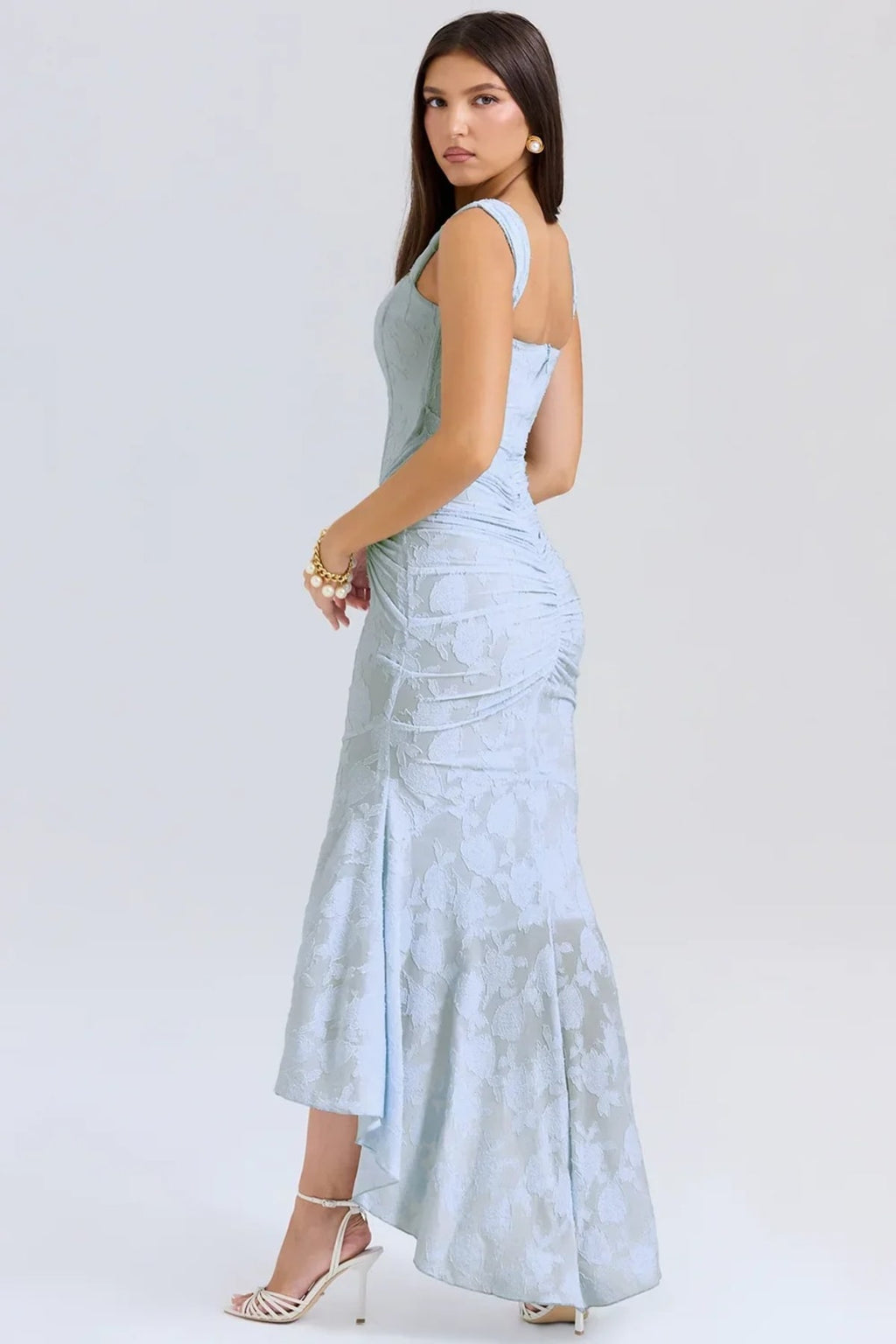 Woman in light blue dress with corset bodice, high-low hem.