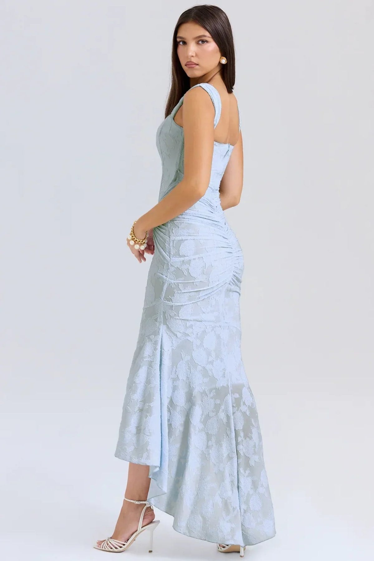 Woman in light blue dress with corset bodice, high-low hem.