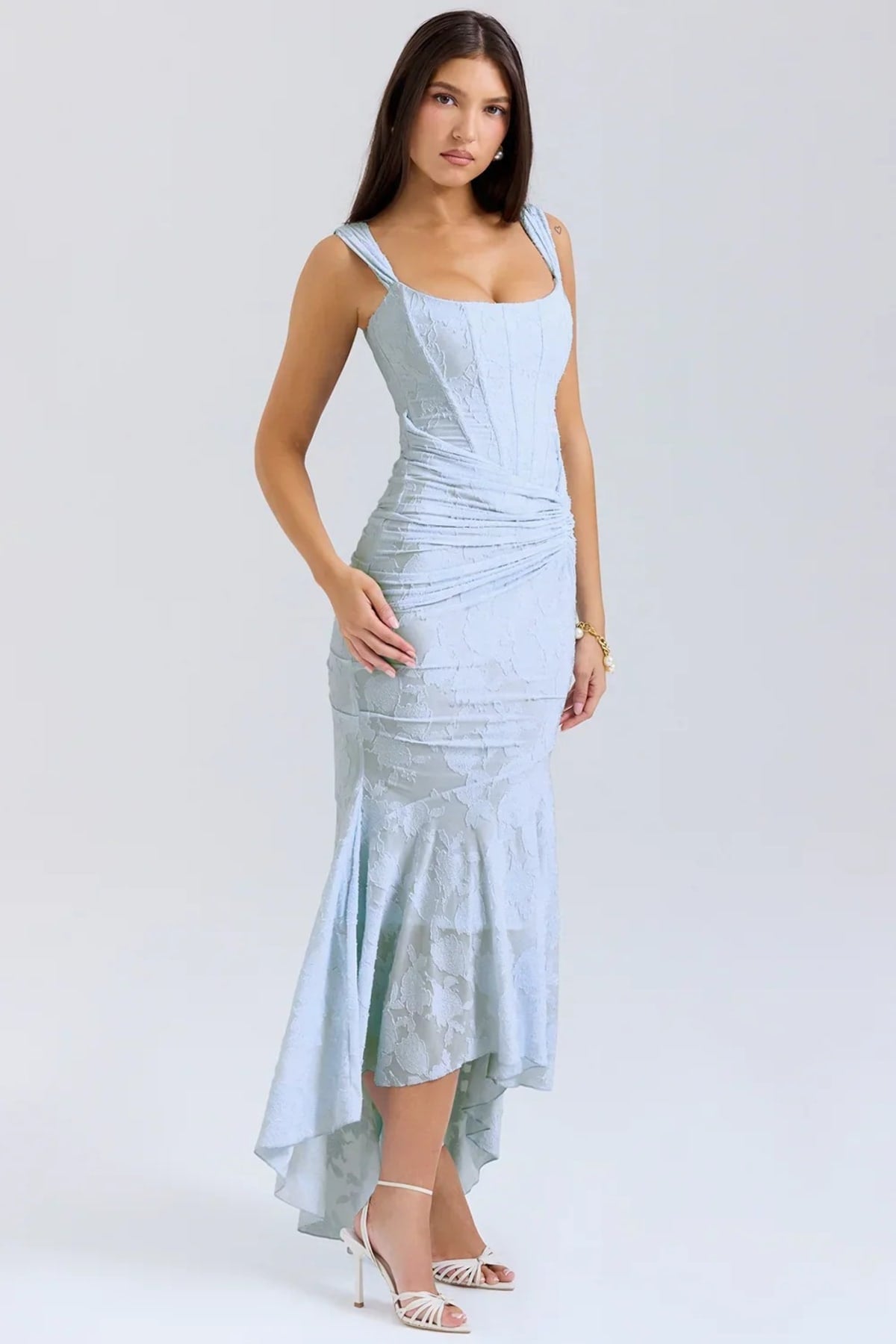 Woman in light blue dress with corset bodice, high-low hem.