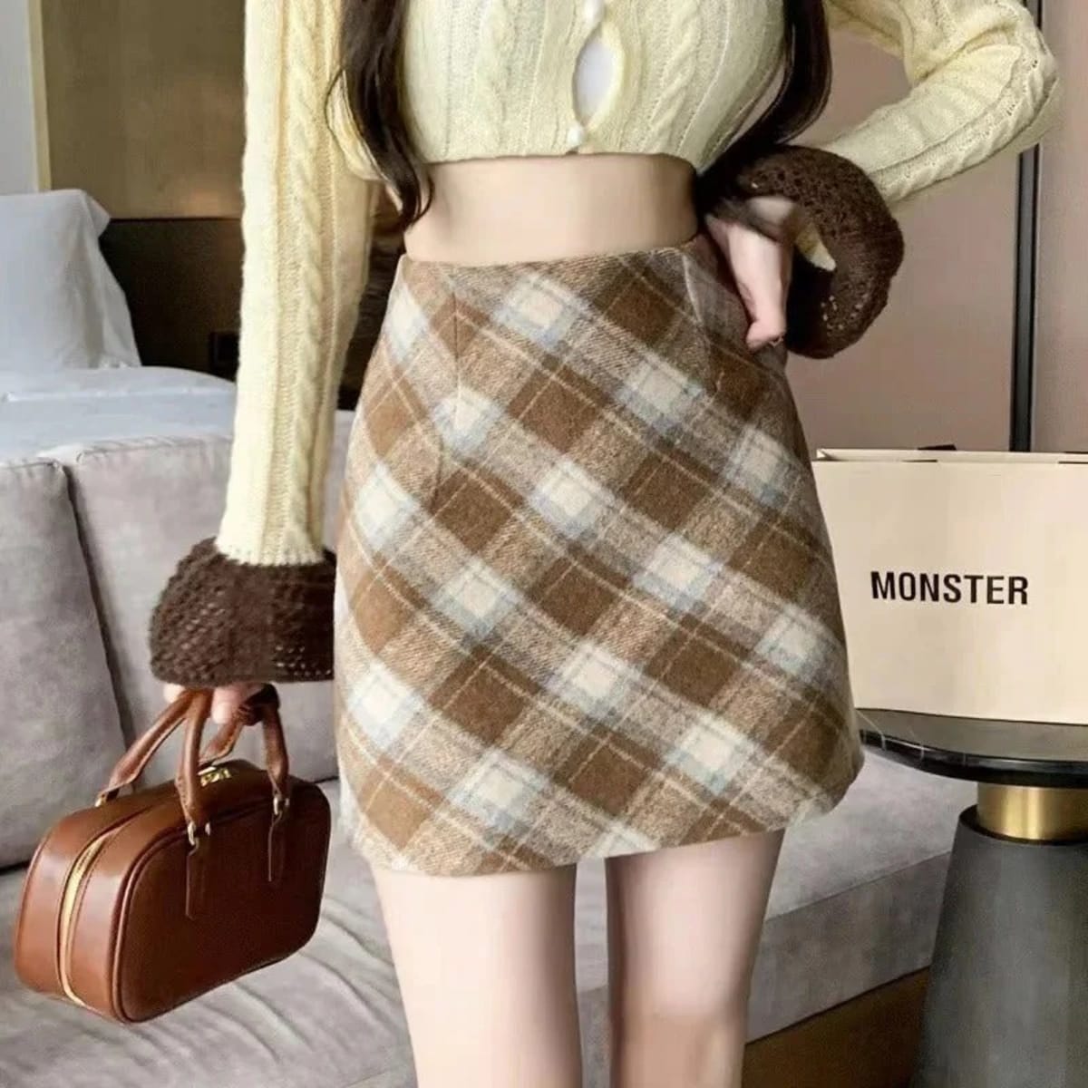 Person wearing a plaid mini skirt with A-line cut.