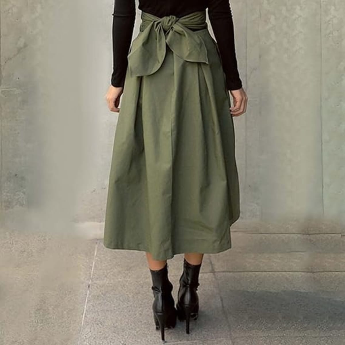 Person wearing high-waisted pleated A-line midi skirt with tie.