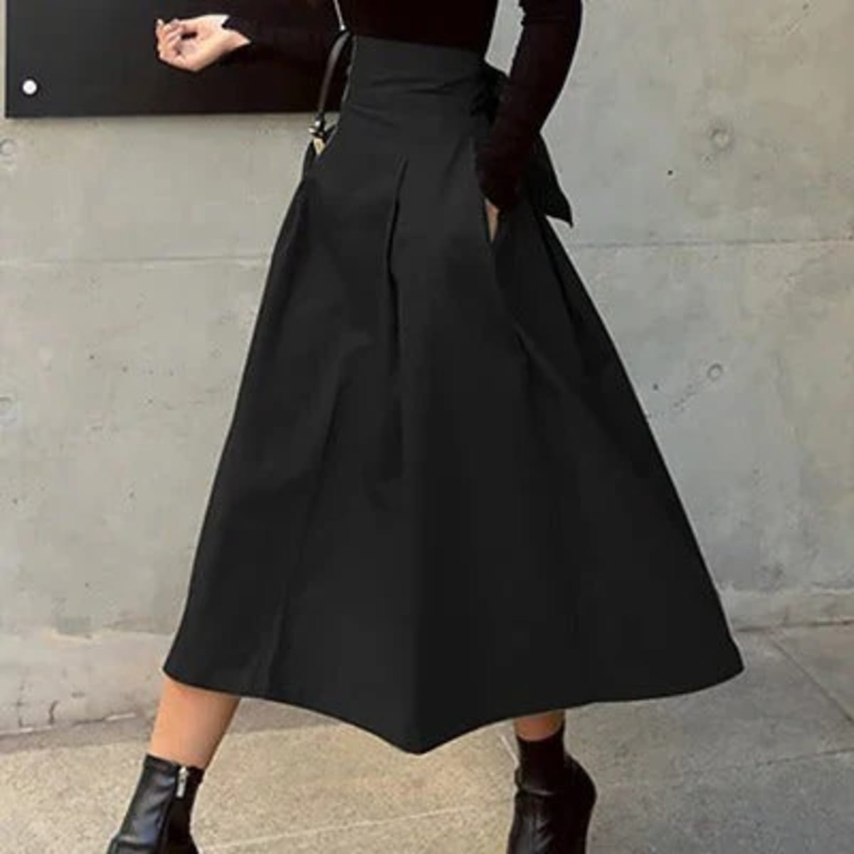 Person wearing high-waisted pleated A-line midi skirt with tie.