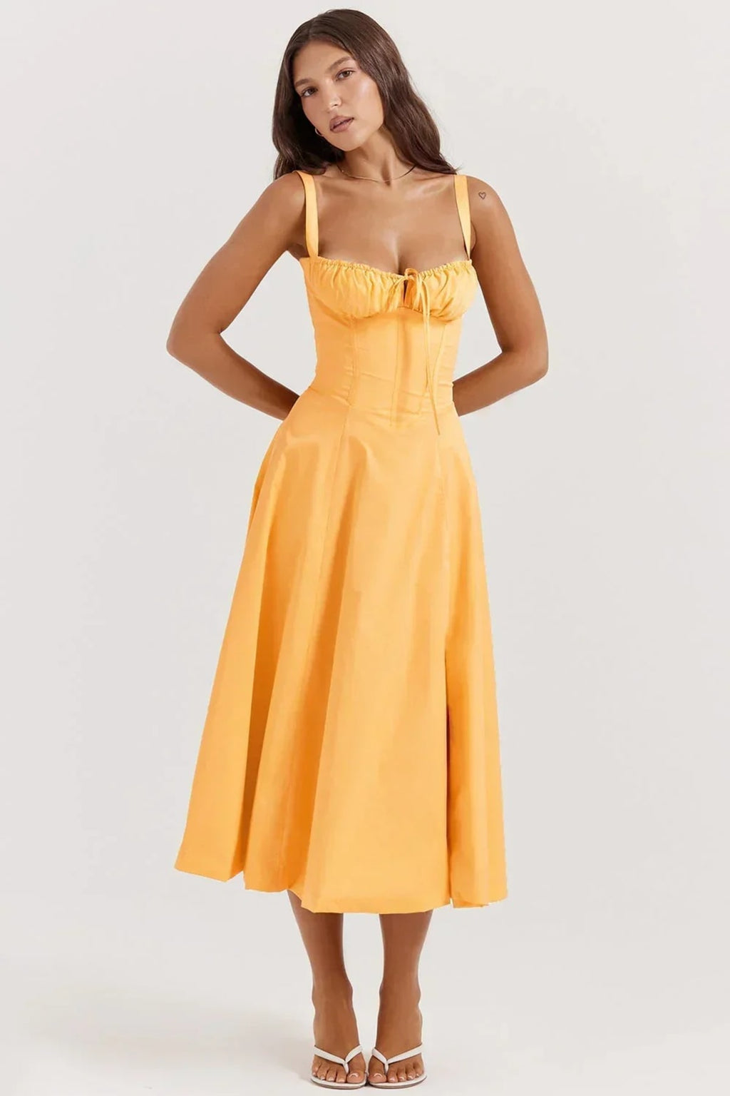 Woman in yellow midi sundress with ruched bust, corset bodice.