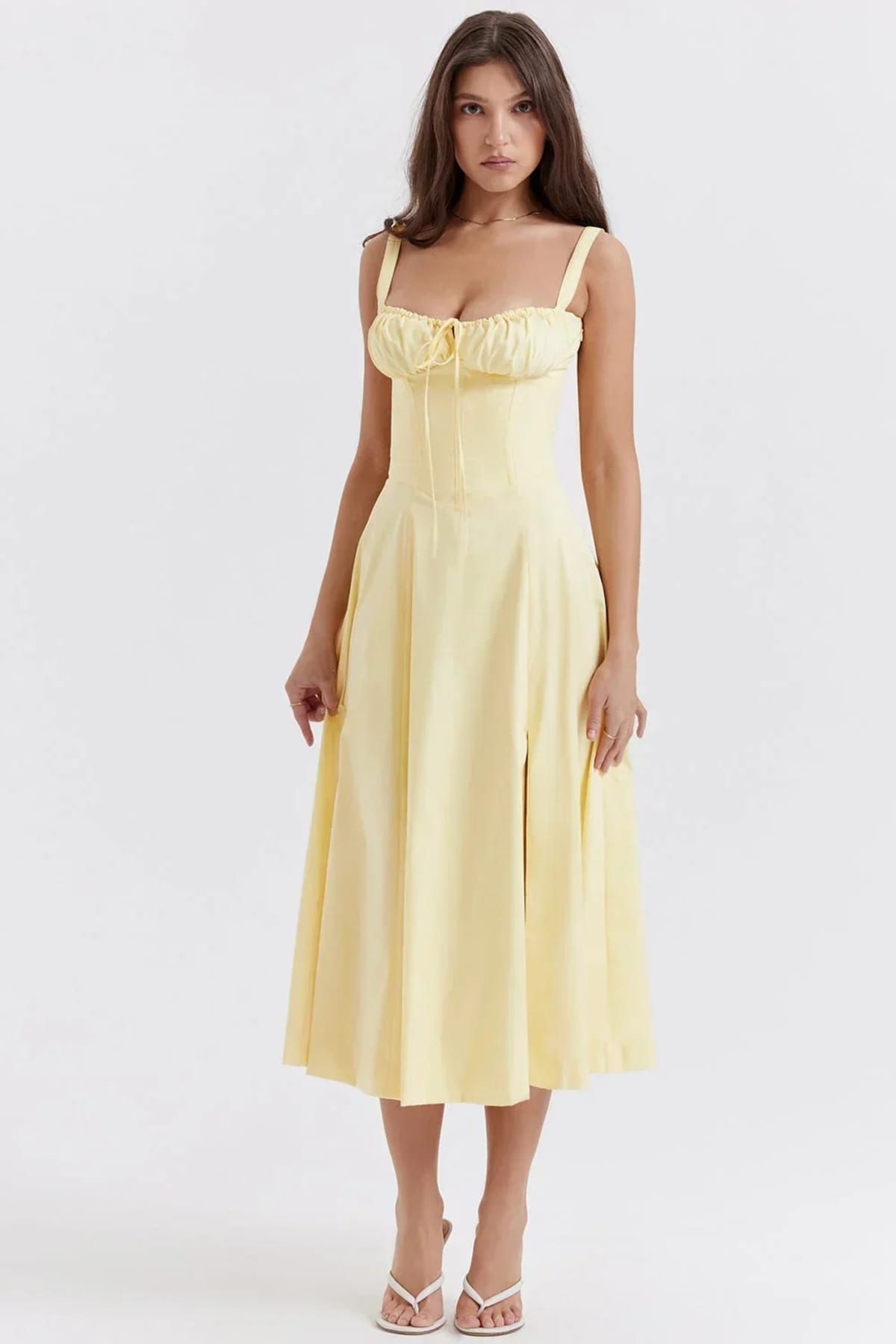 Woman in yellow midi sundress with ruched bust, corset bodice.
