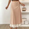 Woman wearing high-waisted layered midi skirt with ruffled hem.