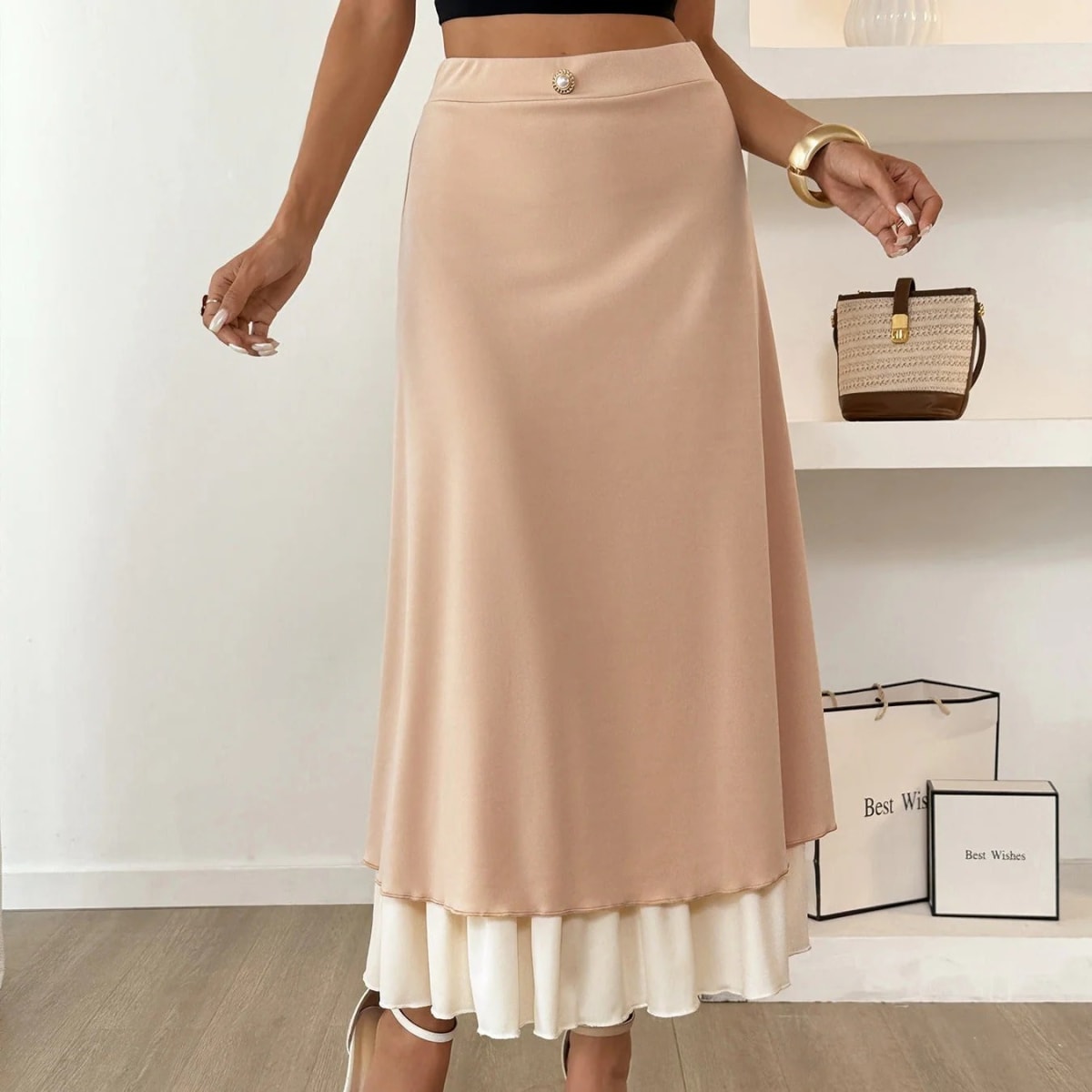 Woman wearing high-waisted layered midi skirt with ruffled hem.