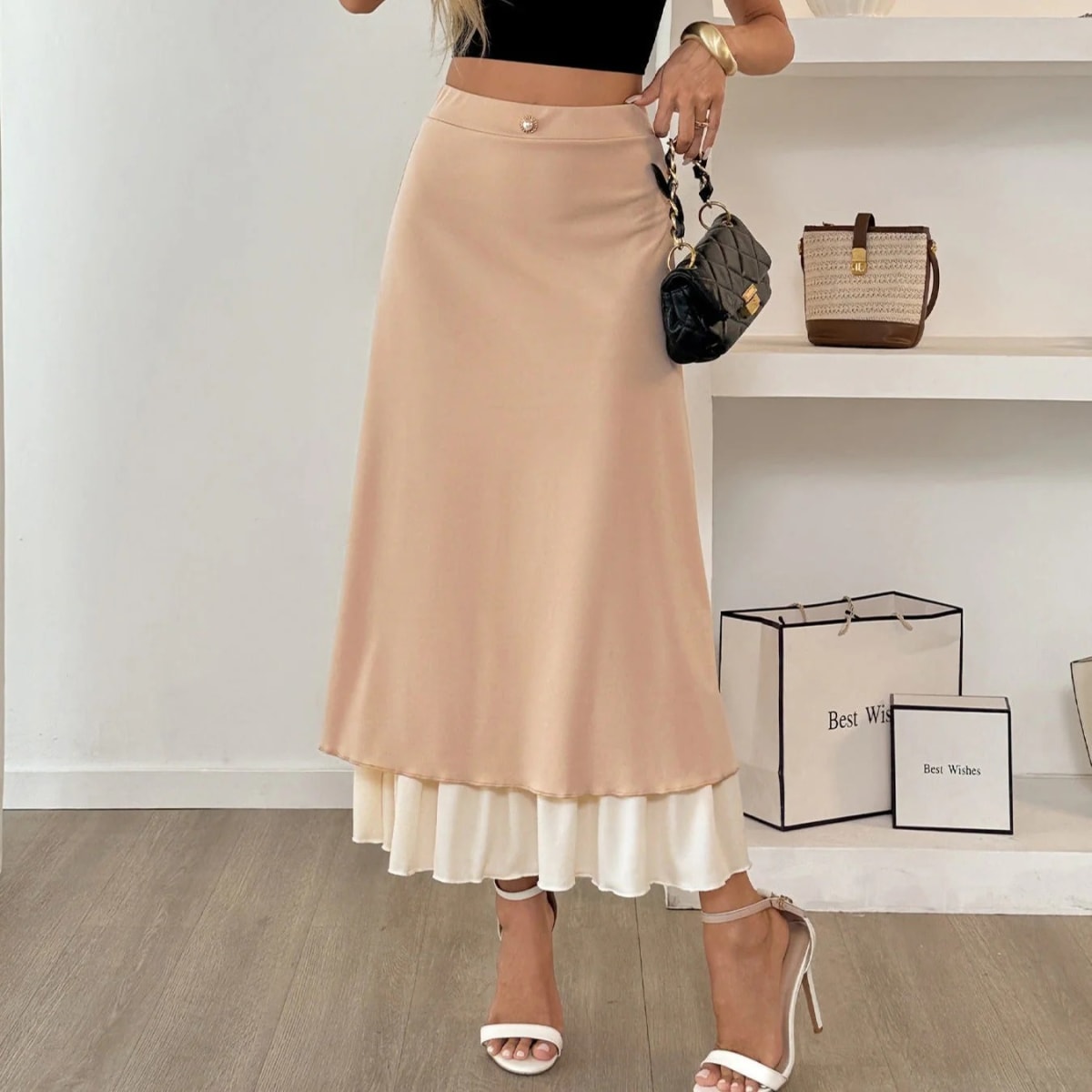 Woman wearing high-waisted layered midi skirt with ruffled hem.