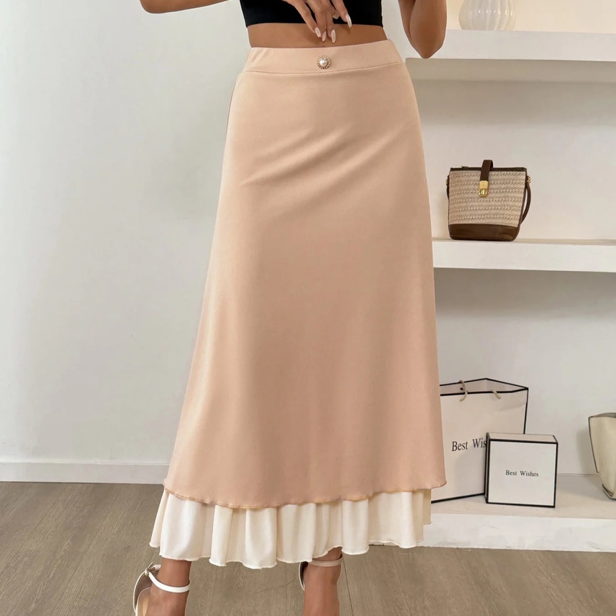 Woman wearing high-waisted layered midi skirt with ruffled hem.