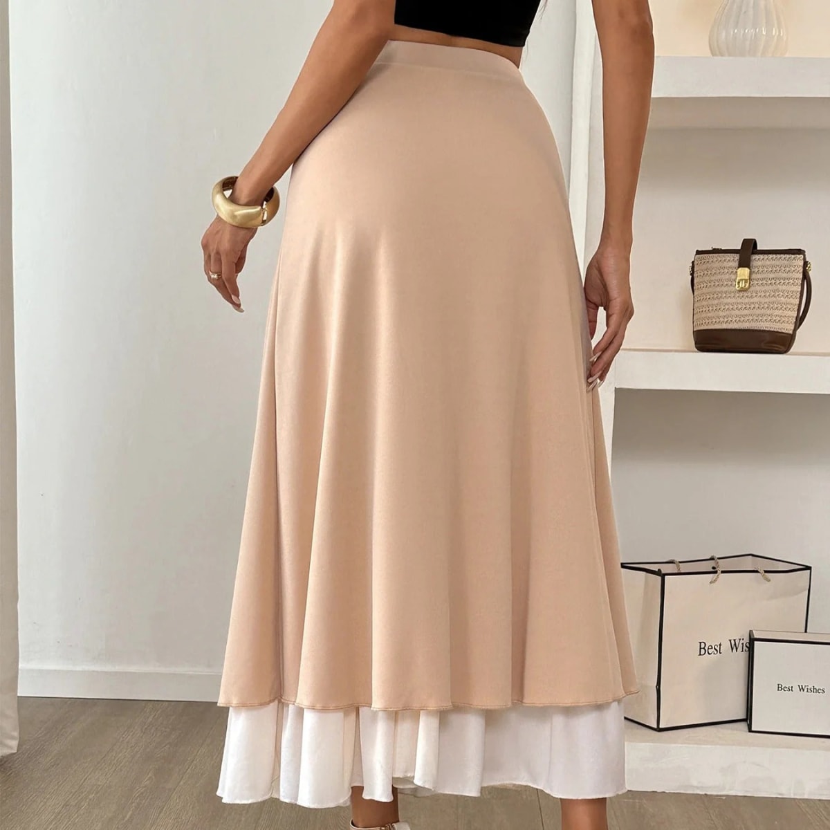 Woman wearing high-waisted layered midi skirt with ruffled hem.