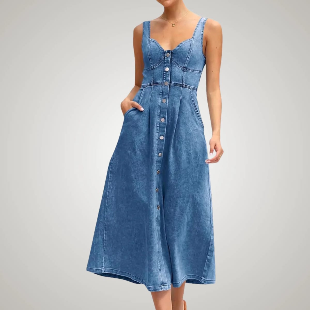 Sleeveless denim dress with button-front and defined fit.