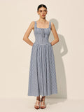 Woman wearing a gingham midi dress with square neck and smocked bodice.