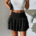 Smocked waist mini skirt with ruffled tiers and crinkled texture.