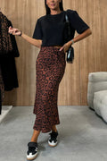 Woman wearing snakeskin print midi skirt with black top.