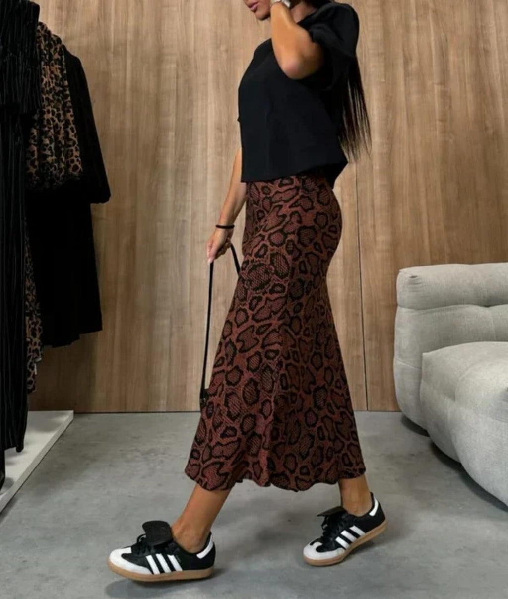 Woman wearing snakeskin print midi skirt with black top.